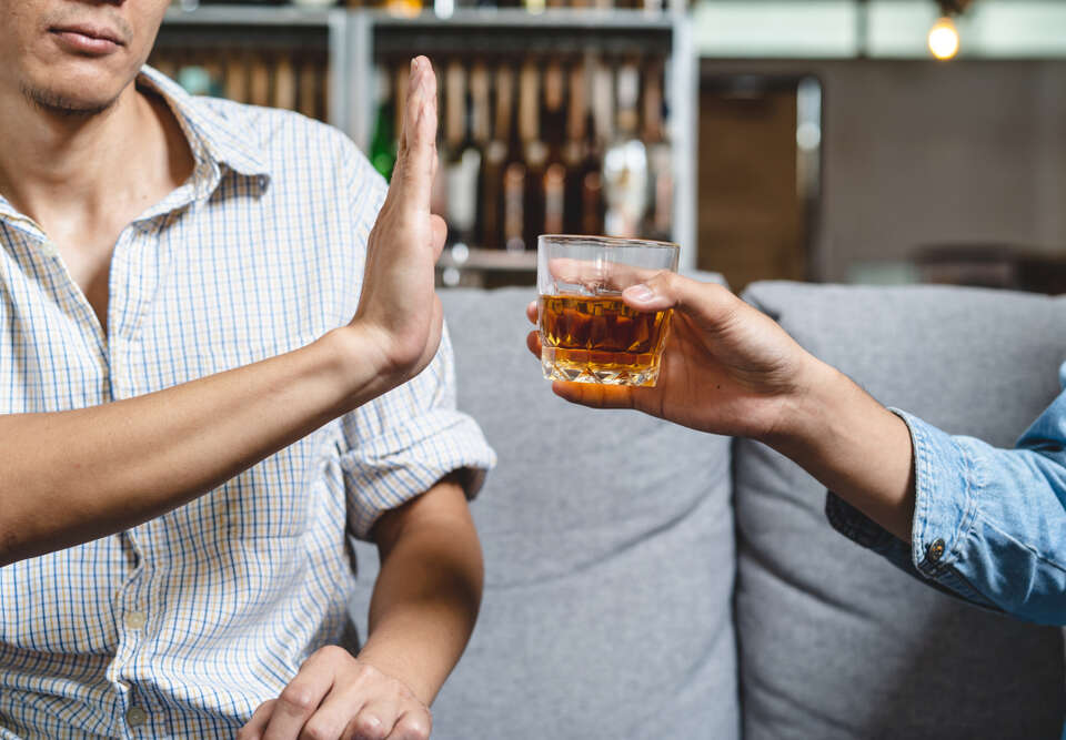 Men refusing an alcoholic beverage while healing from an injury